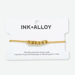 INK + ALLOY Goldie Gold Lurex Cord With Brass Letters Adjustable Peace